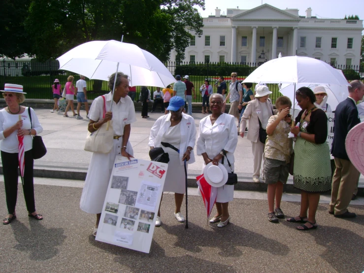 some women in white are holding umbrellas outside