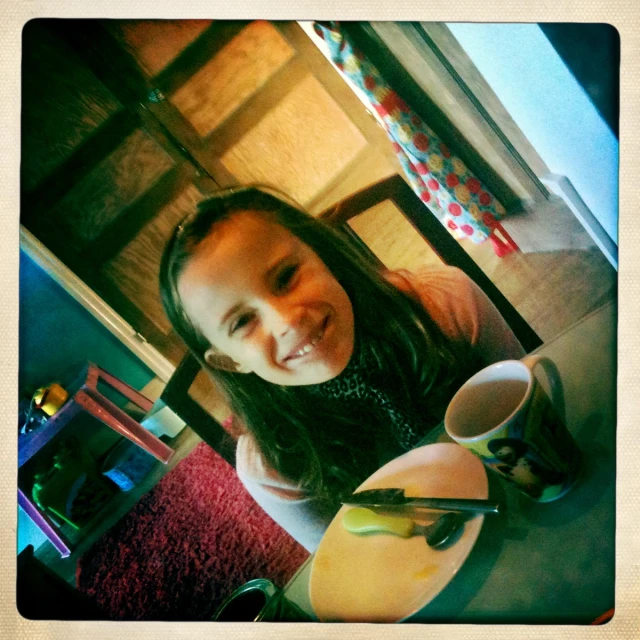 the woman smiles while sitting at her table