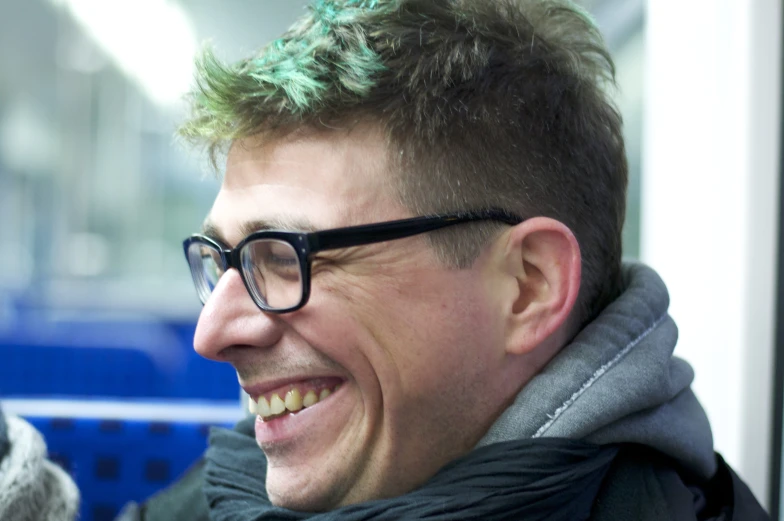 a young man with a green mohawk is sitting down