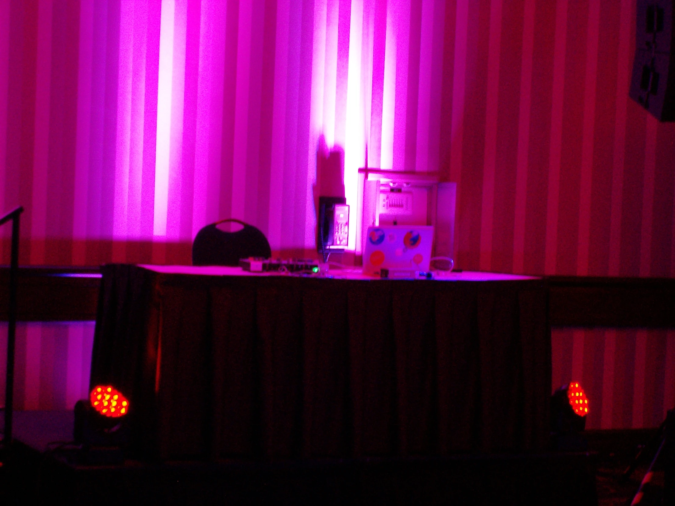 a bright stage with light shining down and a speaker on the table