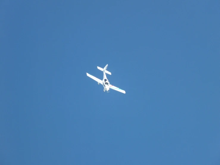 a small plane is flying in the blue sky