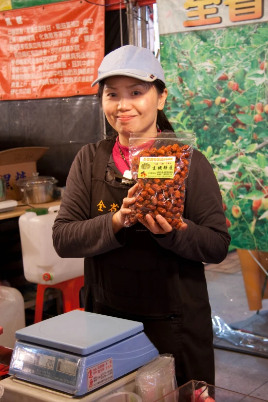 a woman standing behind shelves holding a bag of beans