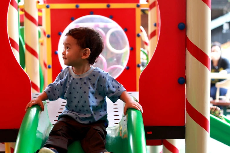 a small boy sits on a merry go round ride