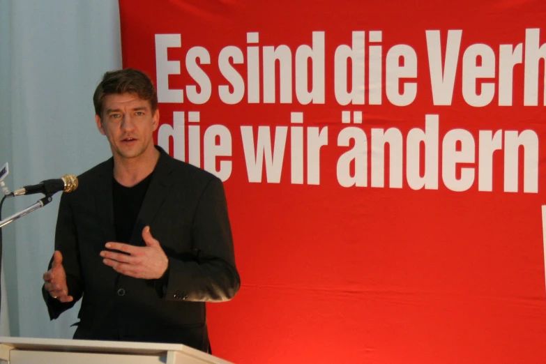 a man stands behind a podium giving a speech