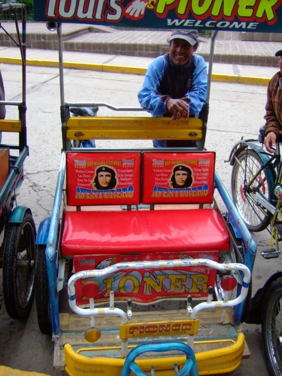 an old man in a cart that has been decorated with posters