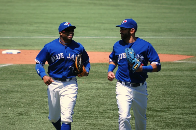 two baseball players standing on the field talking