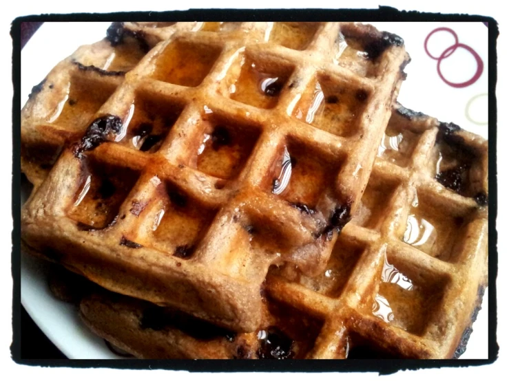 two waffles on a plate covered in syrup