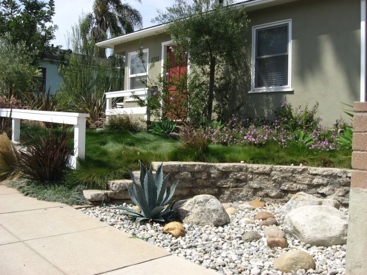 a stone garden bed next to a house