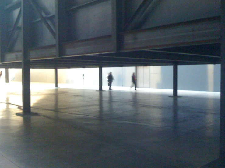 two people are walking in an empty, deserted space