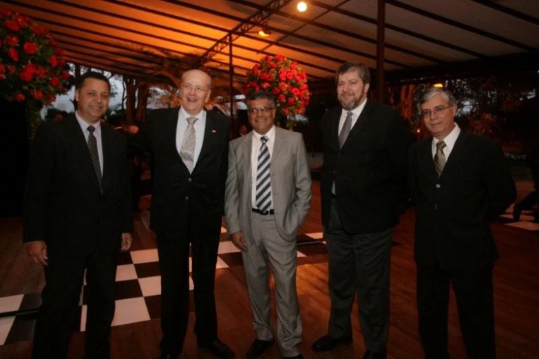 four men in suits and ties are standing in a room