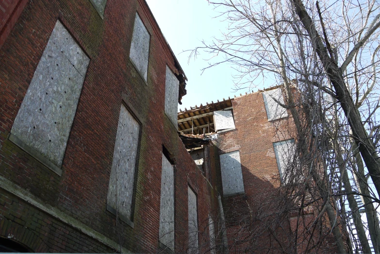 an unfinished brick building with the window openings closed