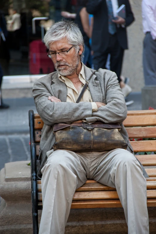 an old man sitting on a bench with his arms crossed