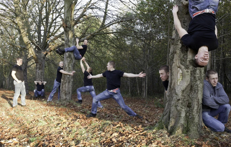 a group of men stretching on tree trunks in the woods