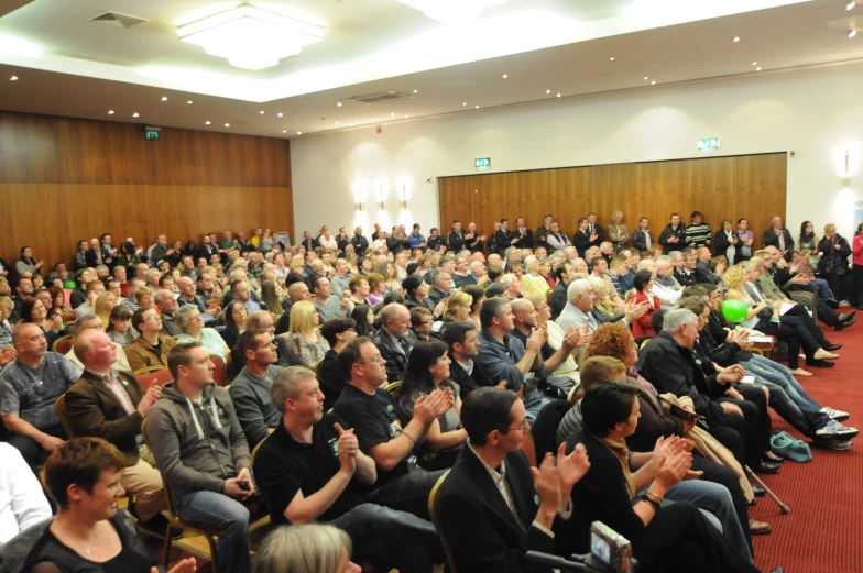 a bunch of people sitting in front of some speakers