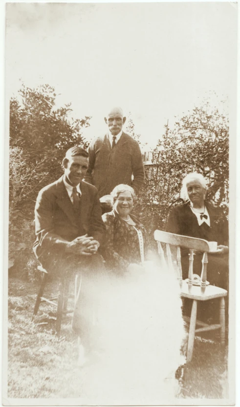 an old pograph of people sitting in a lawn chair