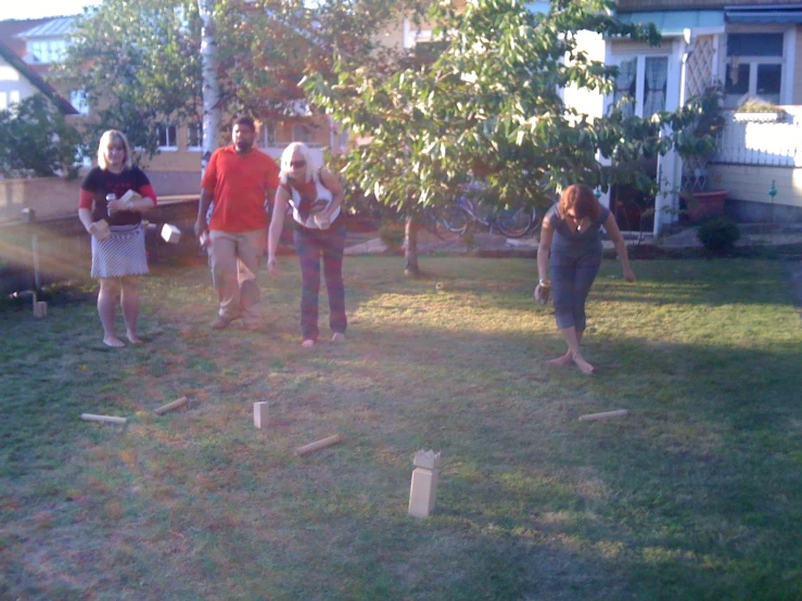 some people playing games in a yard with plastic bats