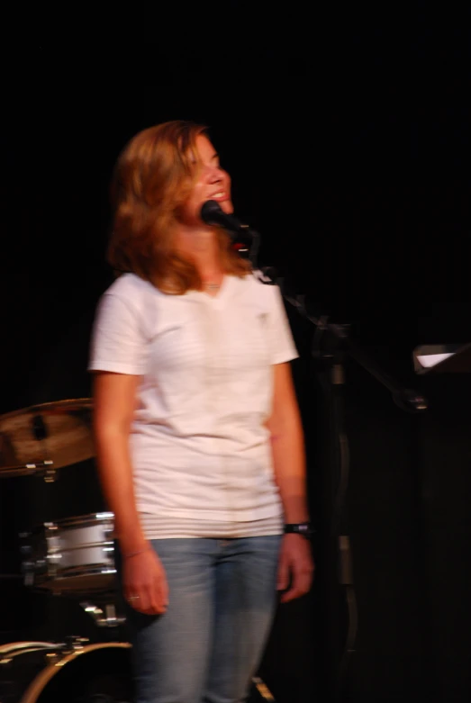 a woman standing in front of a drum kit