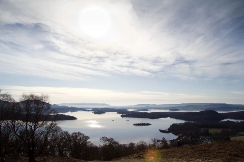 the sun shines on the water and trees