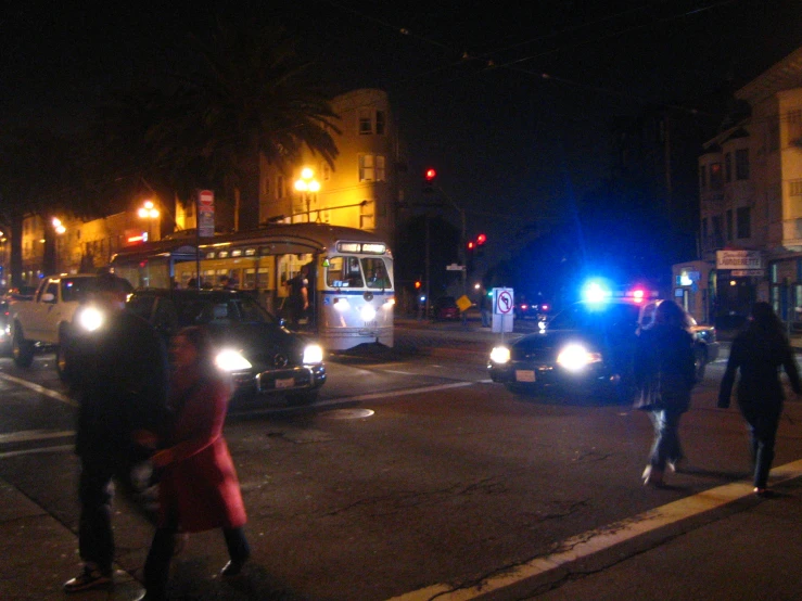 a group of people crossing a street at night