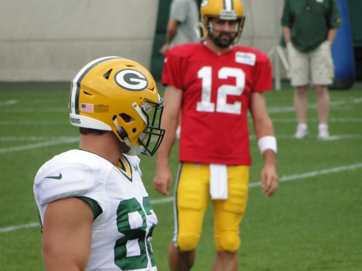 two football players standing next to each other on a field