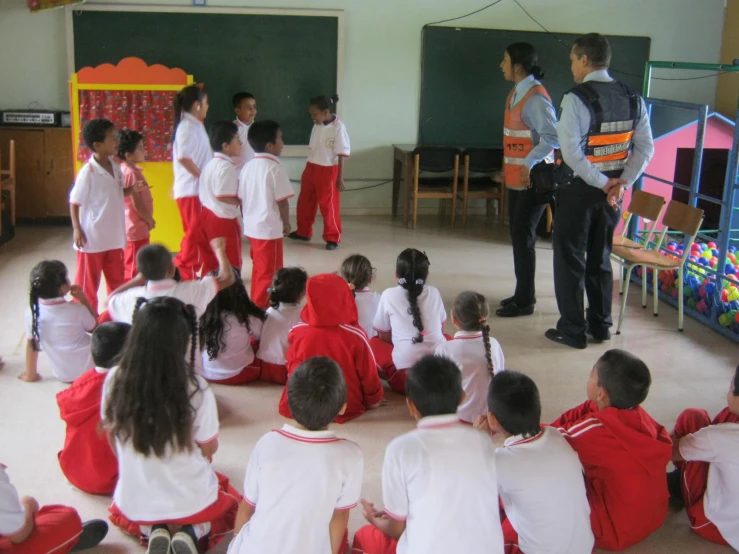 a teacher is teaching children in their school uniforms