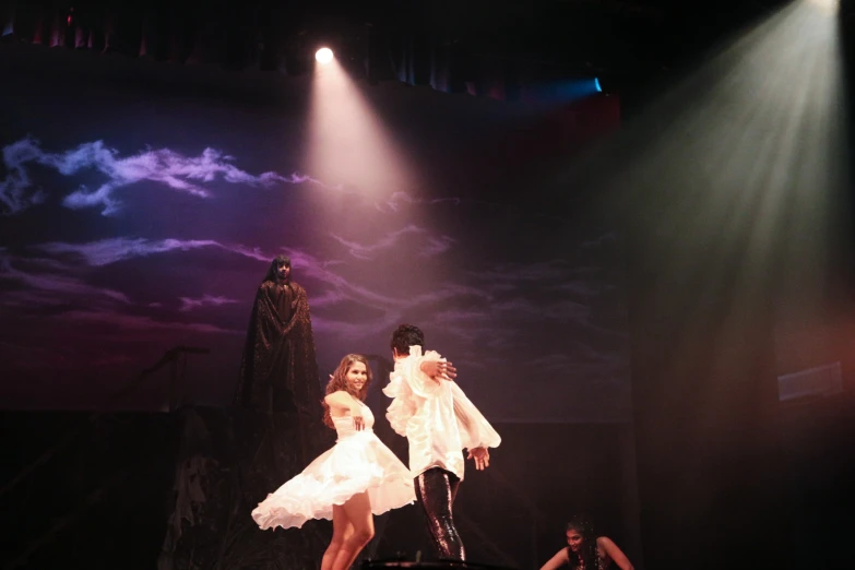 two women dressed in white on stage with head phones