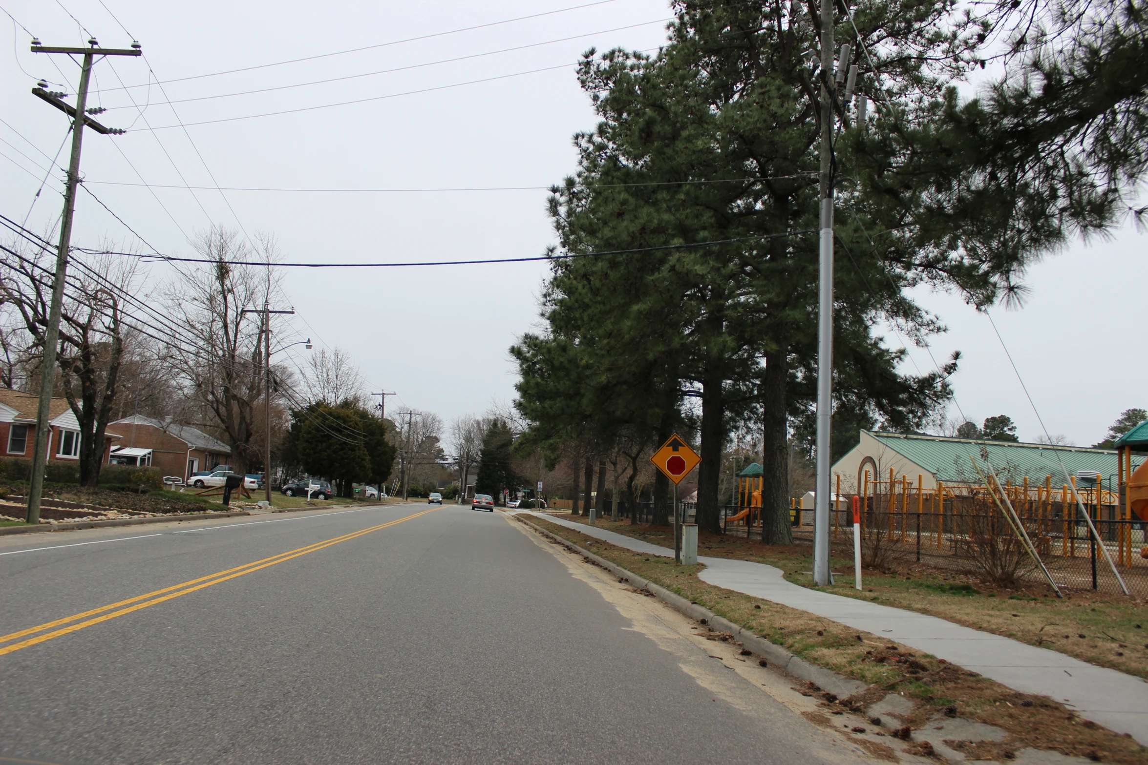 two street signs at the end of an empty street