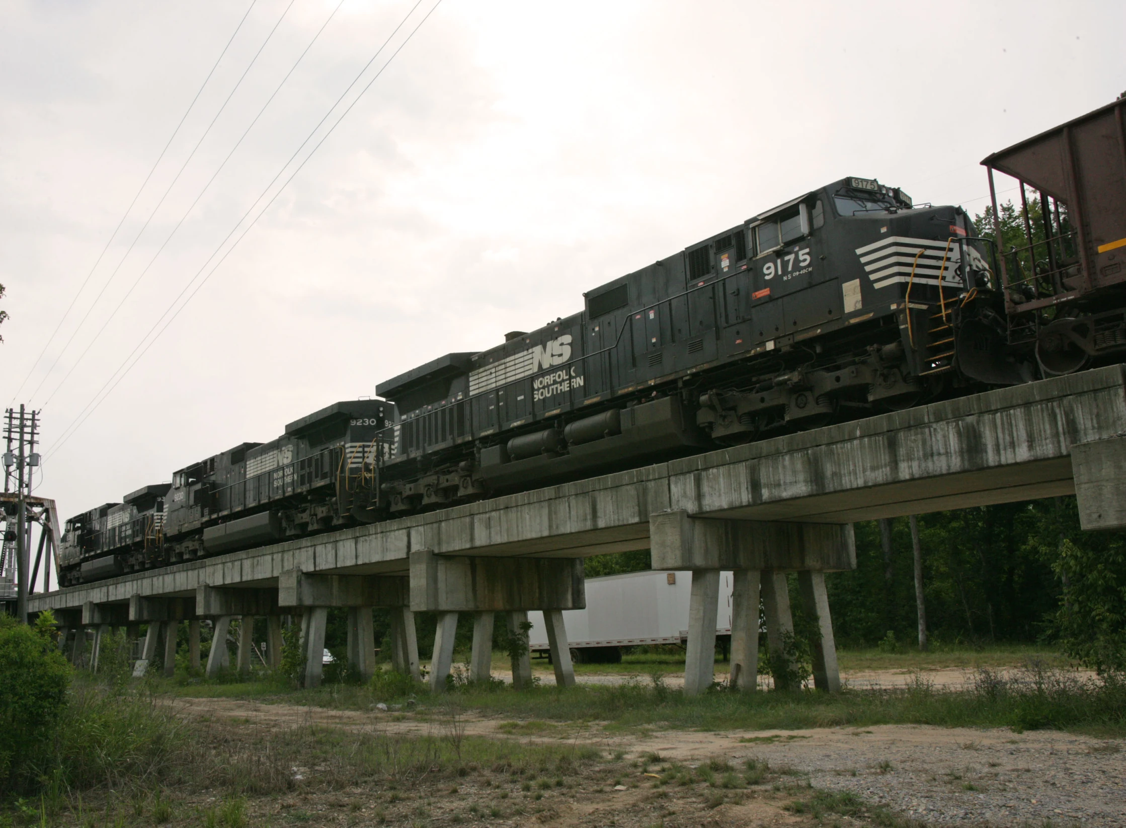 a train going over a concrete road bridge