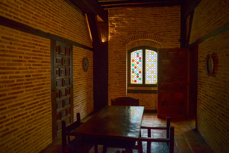 a brick walled kitchen area with stained glass window