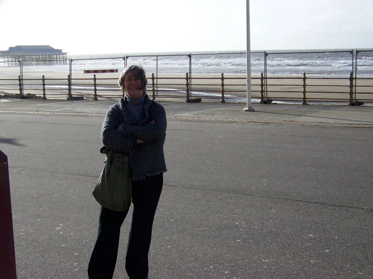 a woman standing on a street with a phone in her hand