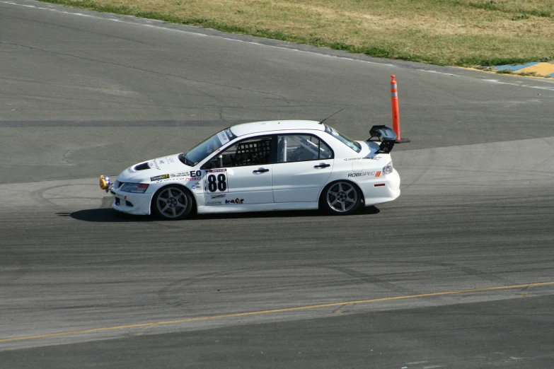 a white race car driving down a race track