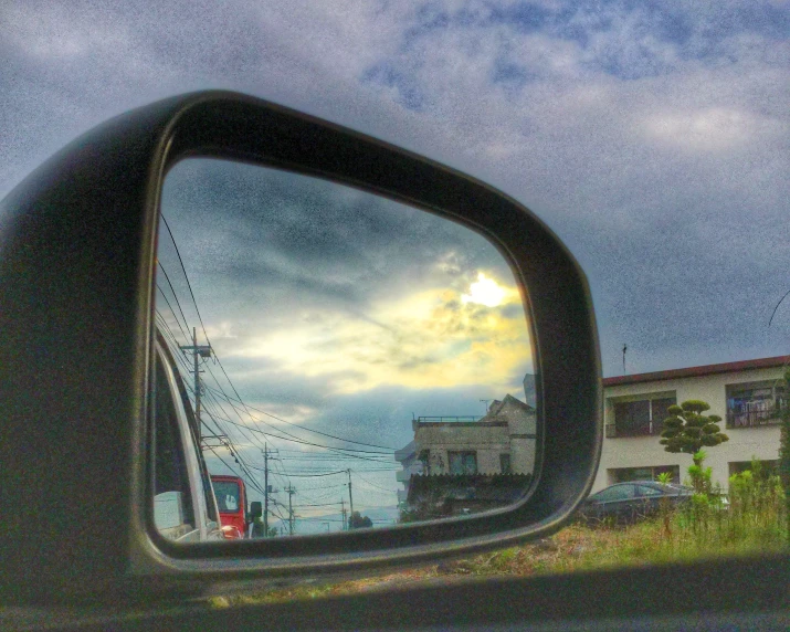 reflection of buildings in a rear view mirror