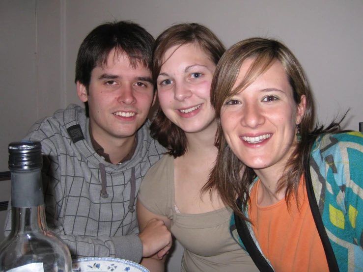 three smiling people are sitting at a table