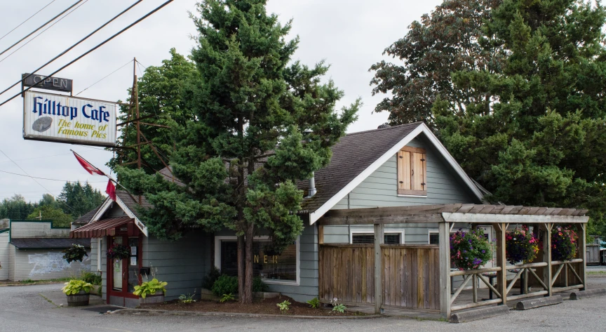 a small gray building sitting on the side of a road