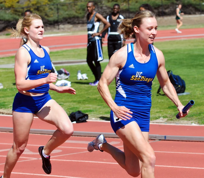 women running on a track in blue uniforms