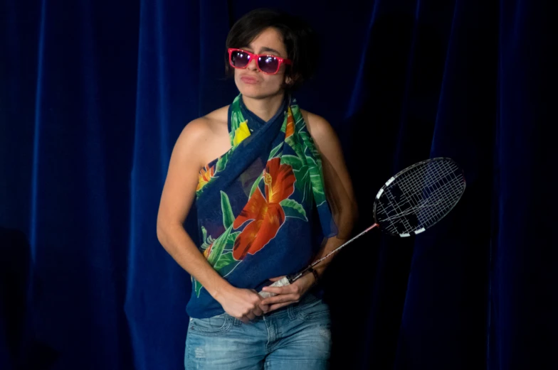 the woman with red sunglasses is standing with her tennis racket