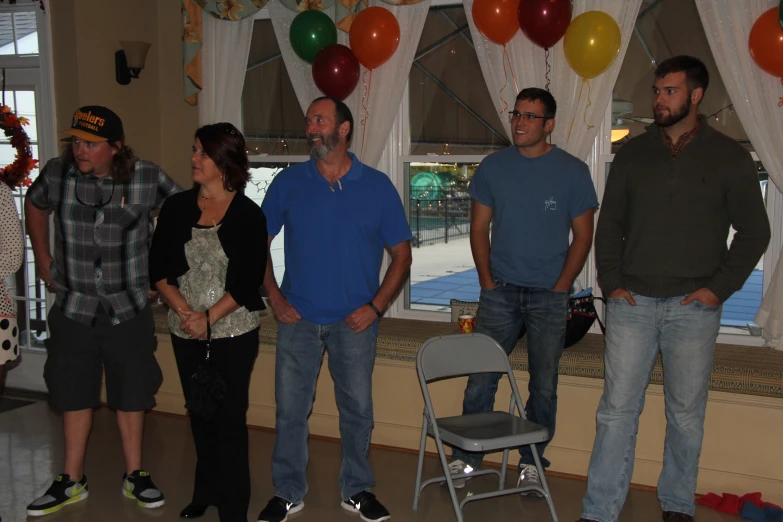 people are standing near some balloons in the room