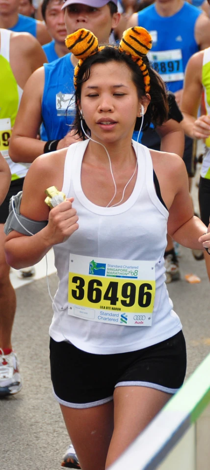 an asian woman running down a marathon course