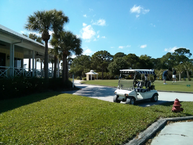 a golf cart parked near a tree lined driveway