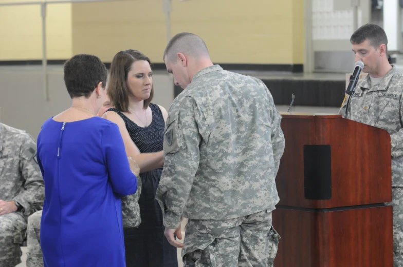 a soldier talking to other military personnel while standing at a podium