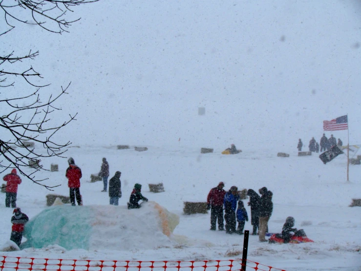 several people stand on an open lot covered in snow
