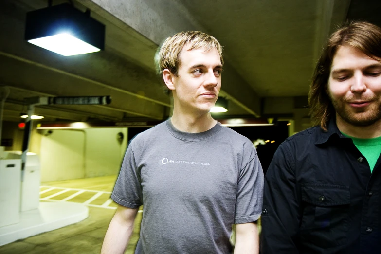 two young men are standing together in a room