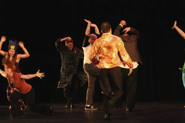 dancers are jumping on stage in a group