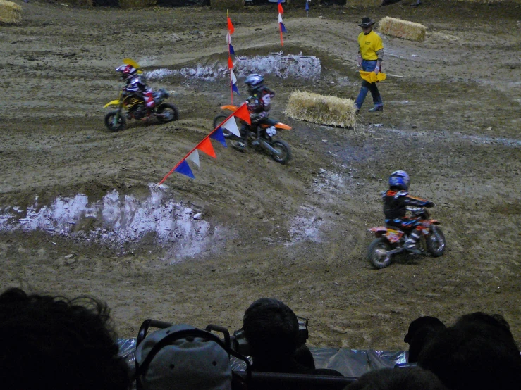 two people on dirt bikes racing around a corner