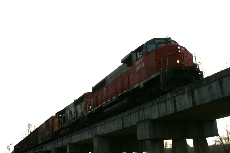 a train on the tracks traveling over an old bridge