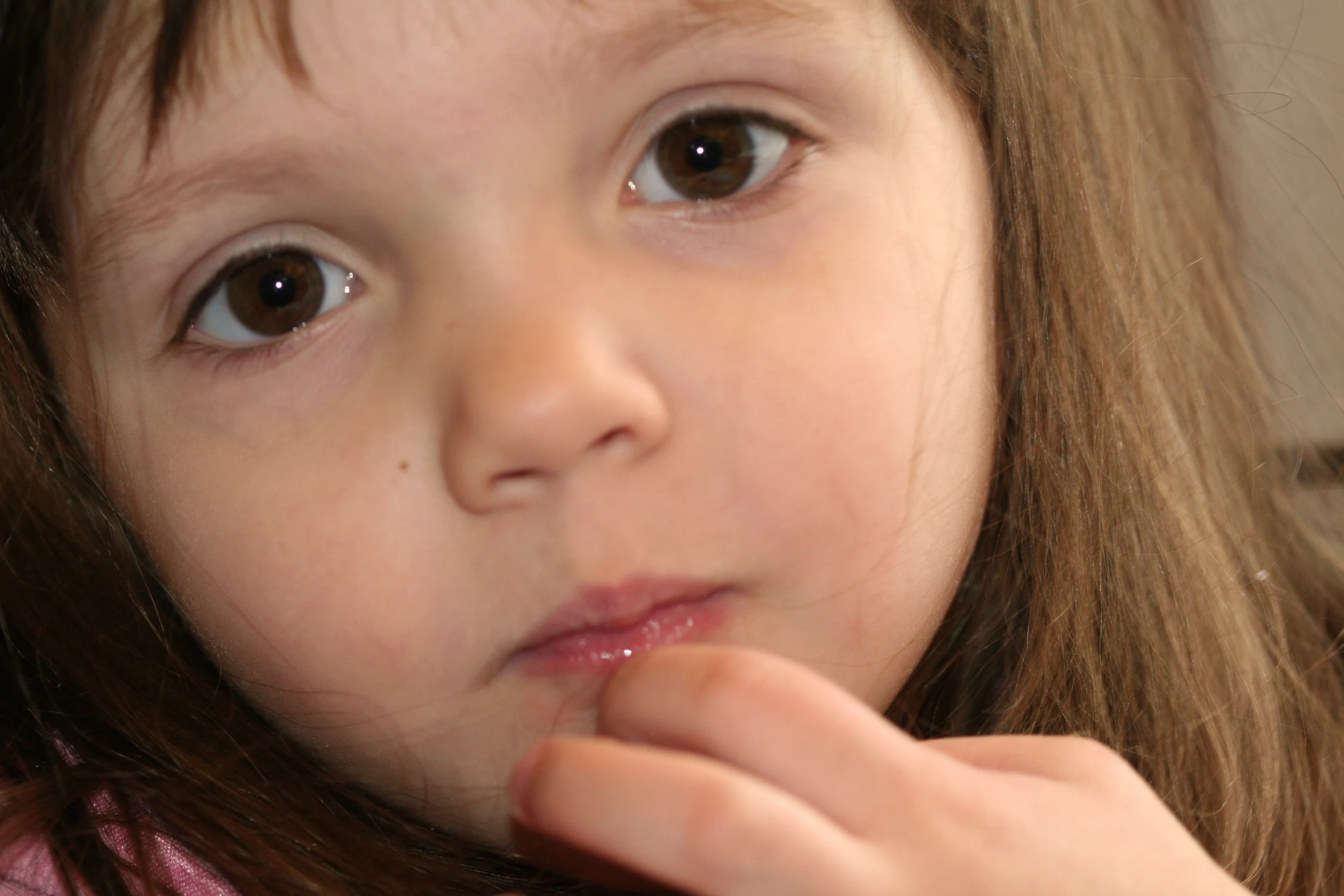 a child is brushing her teeth with pink toothbrush