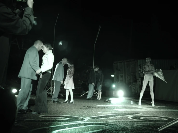 a couple kissing on the end of the road while others watch