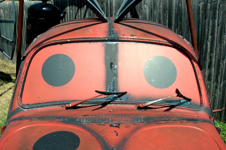 an old red car with large eyes and a pair of scissors