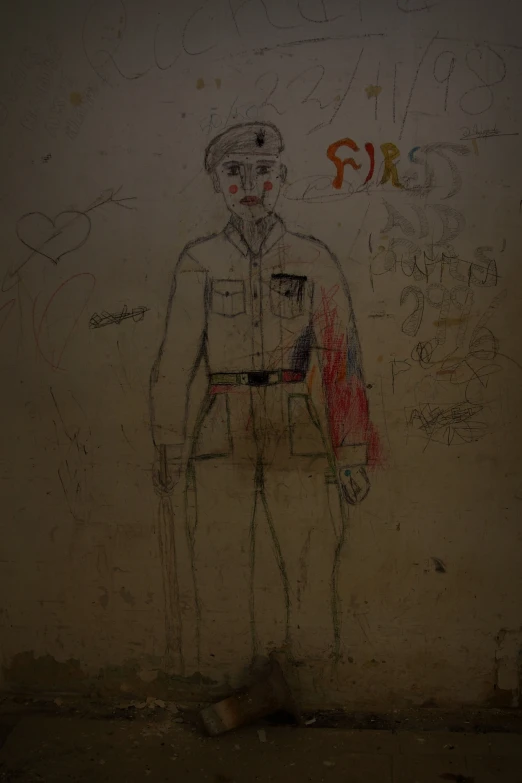 drawing on wall with faded, scratched paint depicting a soldier