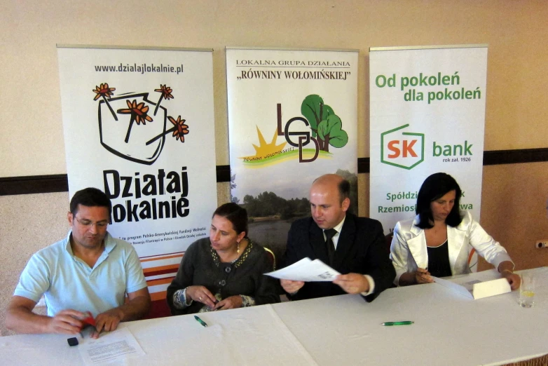 a man and woman sit in front of the table and each have paperwork